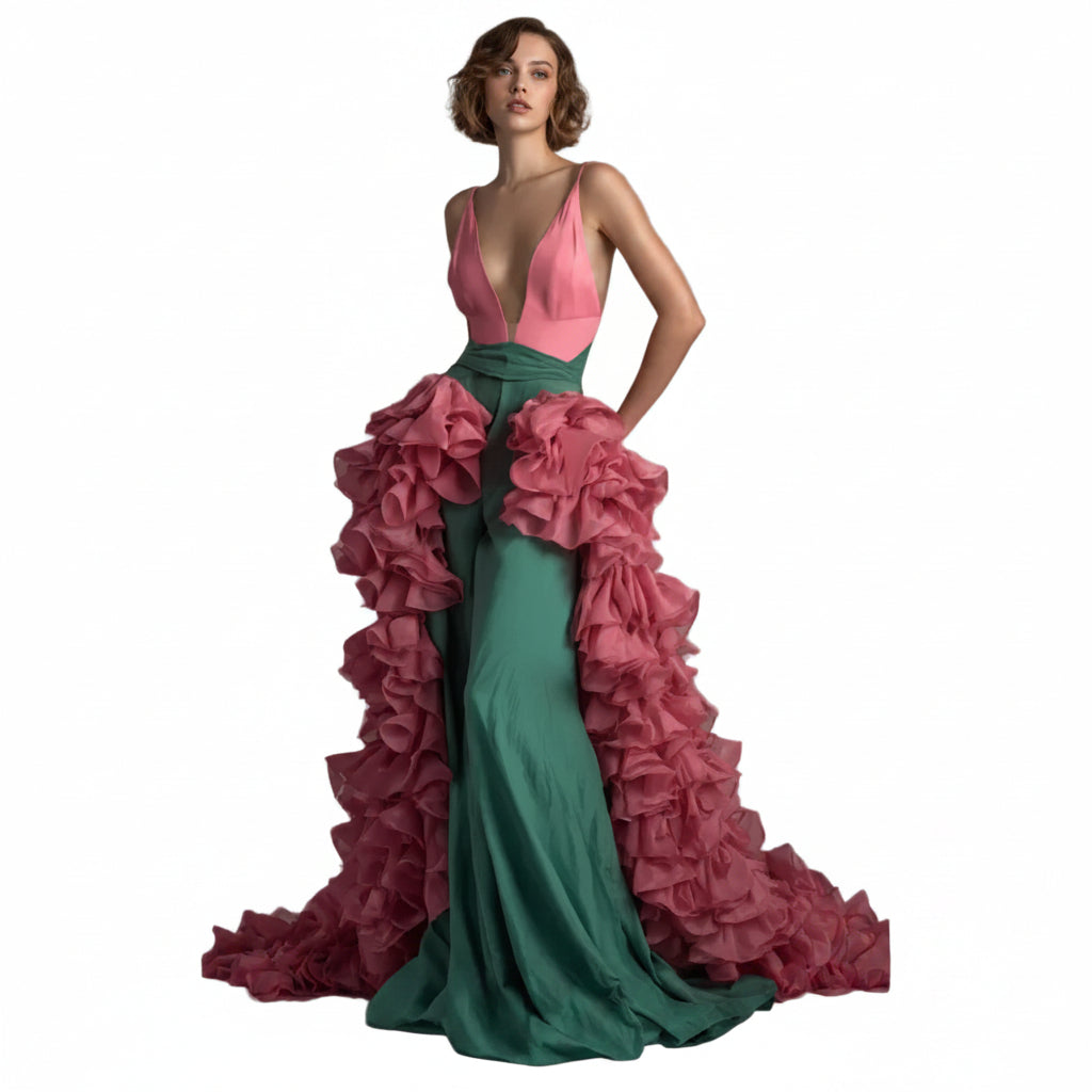 Woman wearing a pink and green gown with ruffled details on a gray background