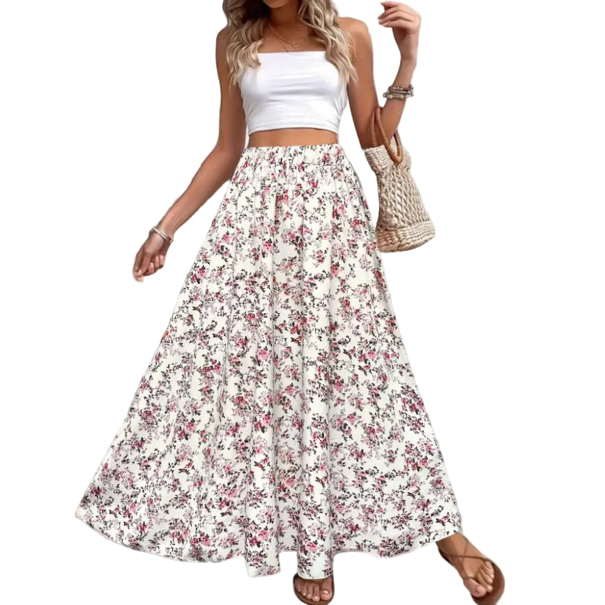 Woman wearing a white floral skirt and top with a woven bag indoors.
