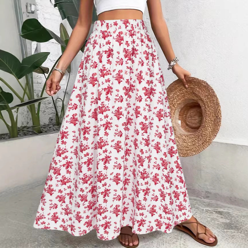 Person wearing a white floral skirt holding a straw hat indoors.