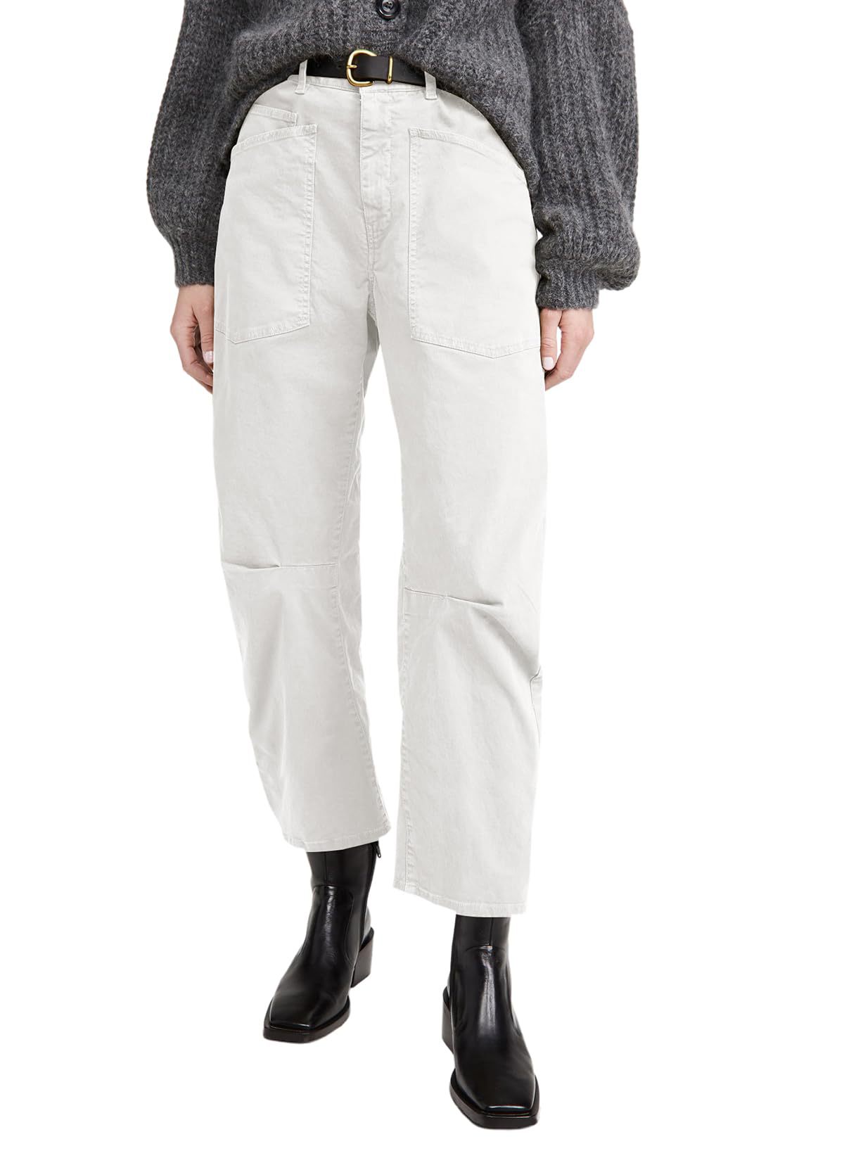 Person wearing white pants and black boots on a white background