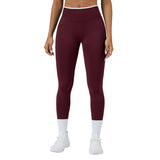 Maroon leggings worn by a person on a gray background
