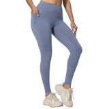 Person wearing blue leggings and white sneakers on a gray background