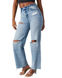 Person wearing distressed blue jeans on a gray background