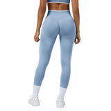 Person wearing light blue leggings on a gray background