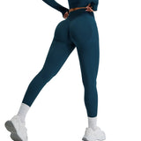 Person wearing teal leggings and white sneakers on a light gray background