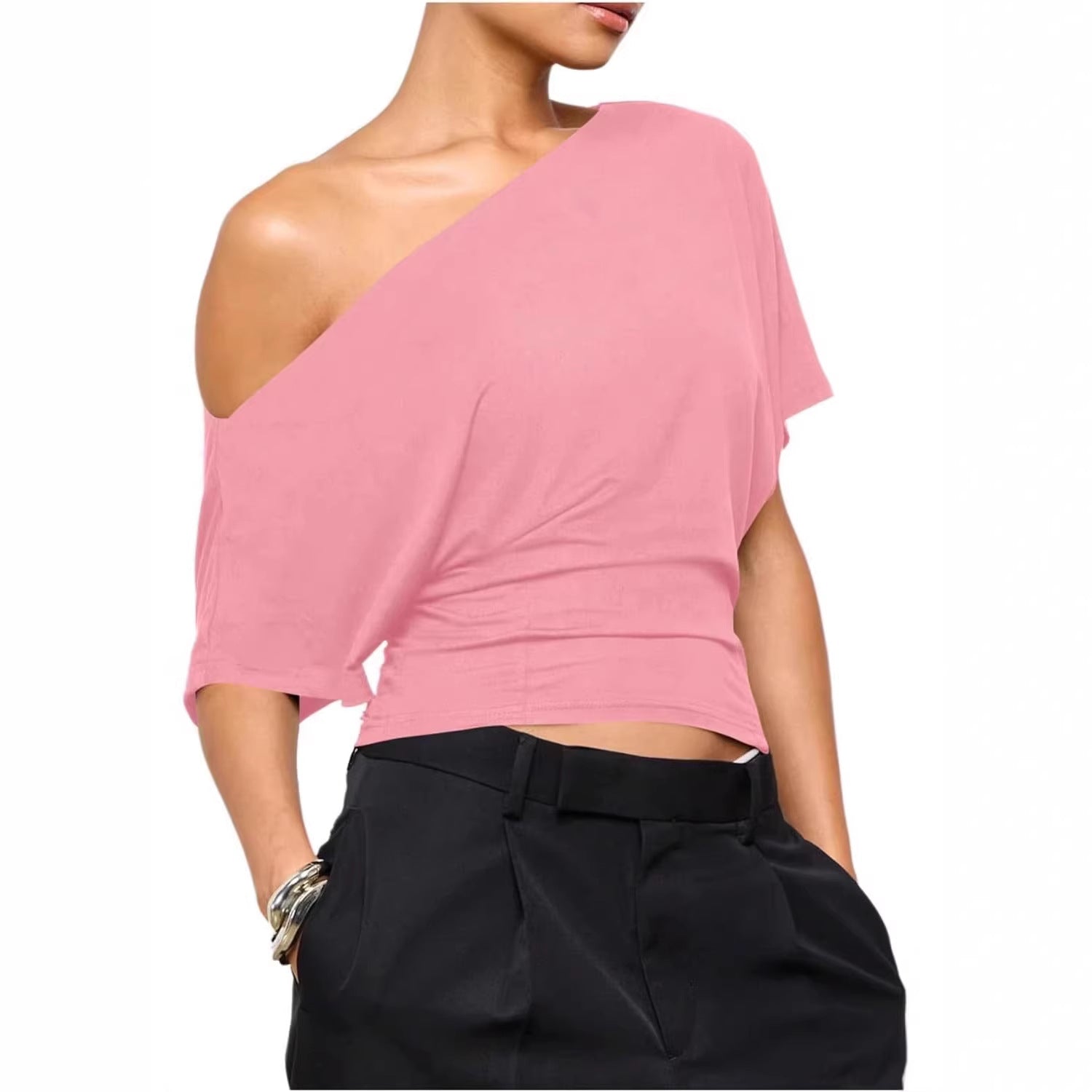 Pink one-shoulder top worn by a person on a white background