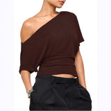 Brown one-shoulder top worn by a model on a white background