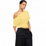 Yellow one-shoulder top worn by a person on a white background