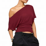 Maroon one-shoulder top worn by a person on a white background