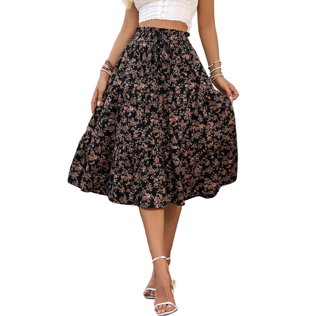 Person wearing a floral skirt on a cobblestone street.