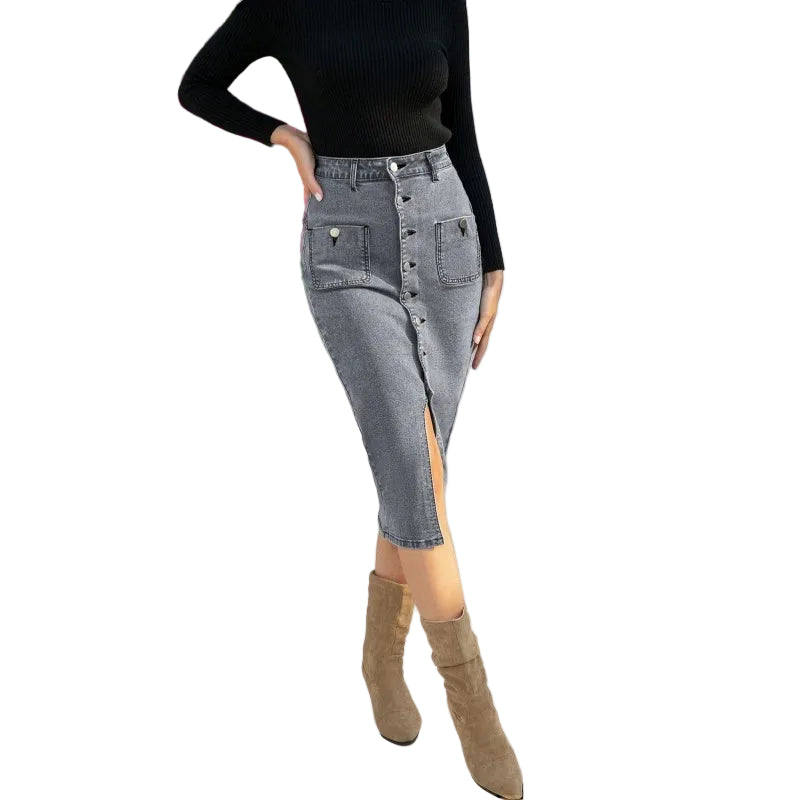 Person wearing a black top and gray button-up skirt with a white background