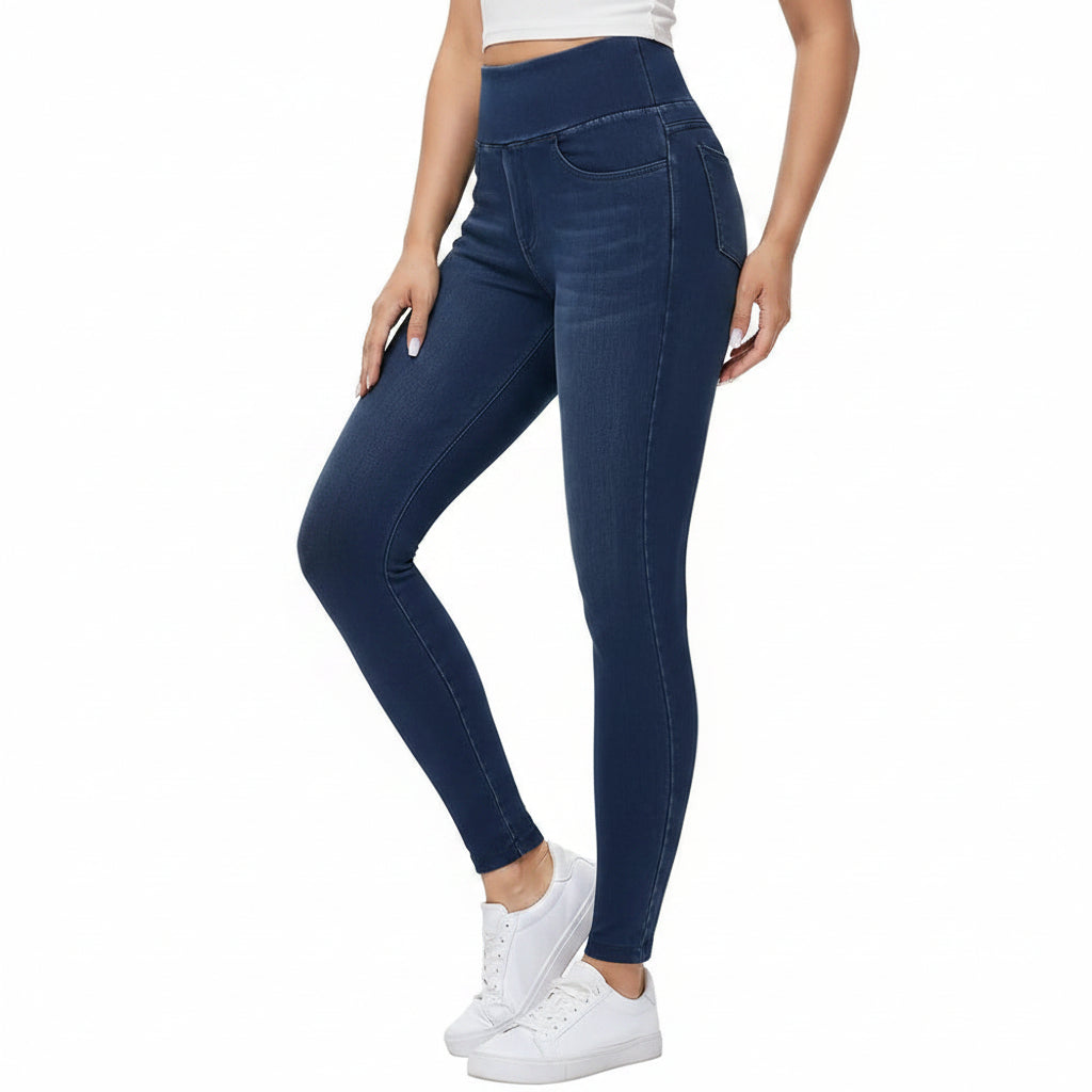 Person wearing blue jeans and white sneakers on a white background