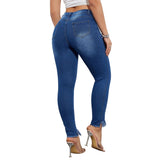 Person wearing blue jeans and high-heeled shoes on a plain background
