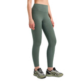 Person wearing green leggings and athletic shoes on a gray background