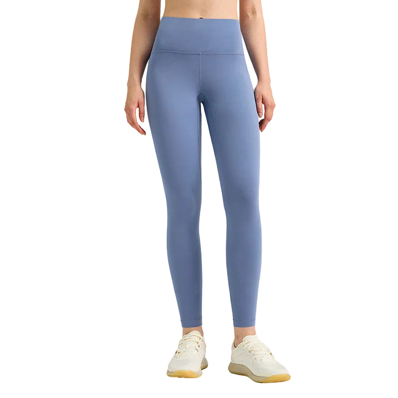 Person wearing blue leggings on a gray background