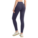 Person wearing dark purple leggings on a light gray background