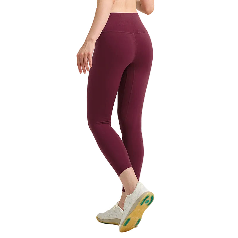 Maroon leggings worn by a person on a gray background