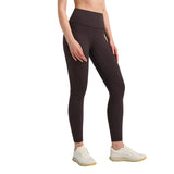 Person wearing brown leggings and white sneakers on a gray background