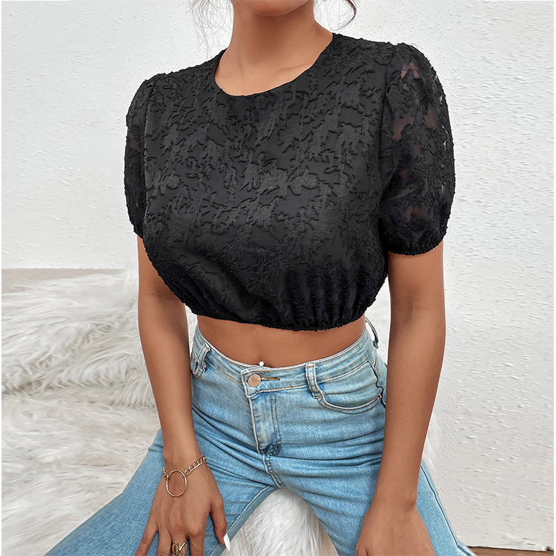 Person wearing a black lace top and blue jeans against a white background