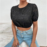 Person wearing a black lace top and blue jeans against a white background