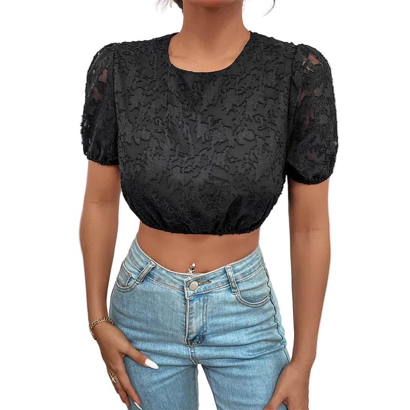 Person wearing a black lace top and blue jeans against a white background
