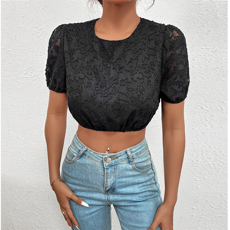 Person wearing a black lace top and blue jeans against a white background