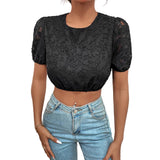 Person wearing a black lace top and blue jeans against a white background