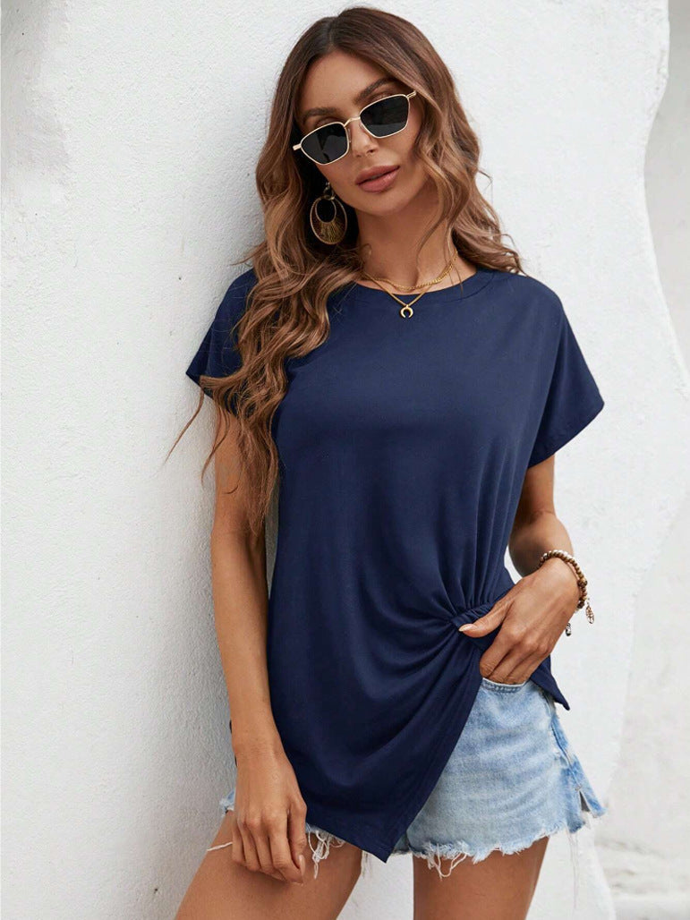 Woman wearing a navy blue t-shirt and denim shorts against a white background